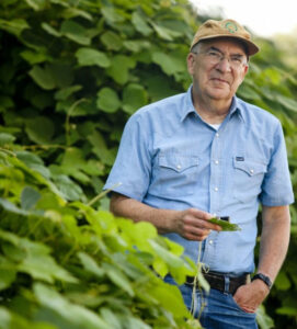 Daniel Simberloff stands in a field of green leaves